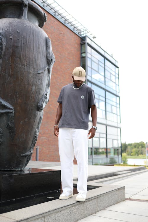 Man Standing and Posing near Sculpture 