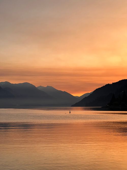 Free Beautiful sunset over Lake Wakatipu in Queenstown, New Zealand, with tranquil waters and silhouetted hills. Stock Photo