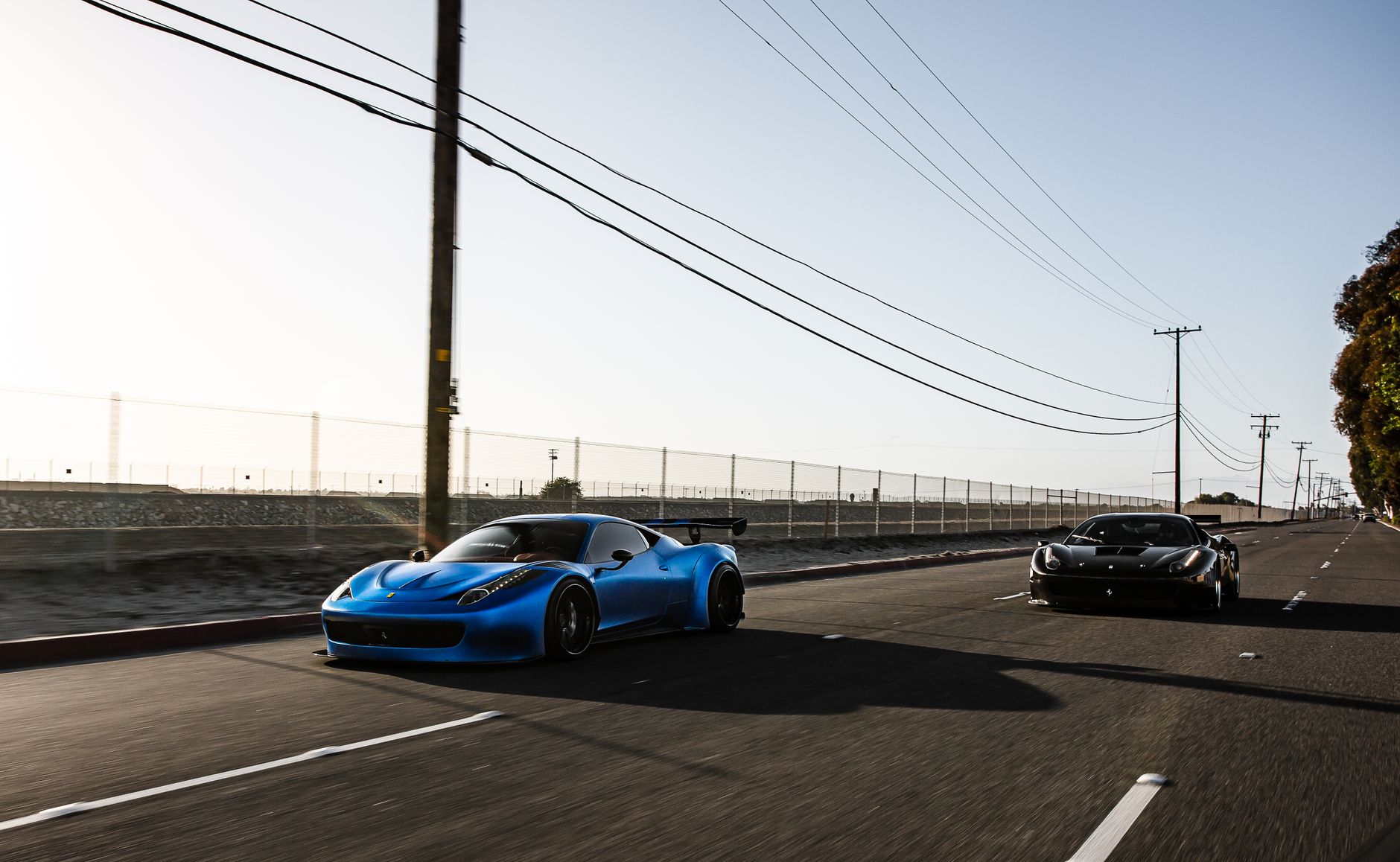 Exotic car driving along Pacific Coast Highway in Los Angeles at sunset