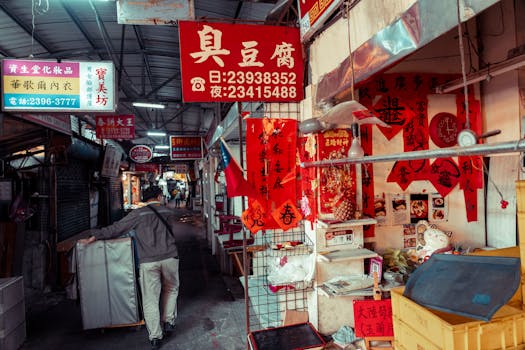 A vibrant street market scene featuring a vendor organizing items under colorful signs.
