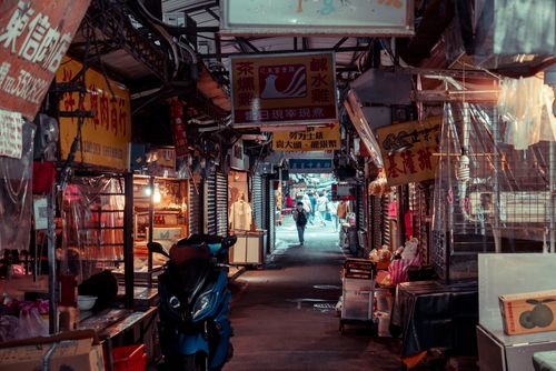 Free Explore a bustling urban market alley filled with colorful signs and vibrant stalls, capturing a lively city atmosphere. Stock Photo