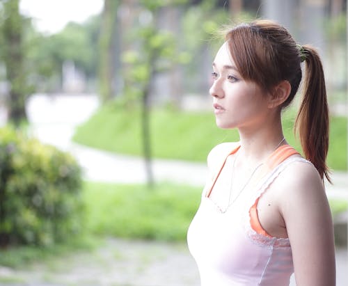 Woman in White Tank Top With Green Leafed Plant during Daytime in Tilt Shift Photography