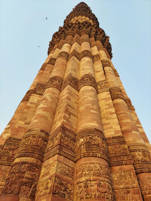 Free Low angle shot of Qutub Minar in Delhi, showcasing its intricate Islamic architecture against a clear sky. Stock Photo
