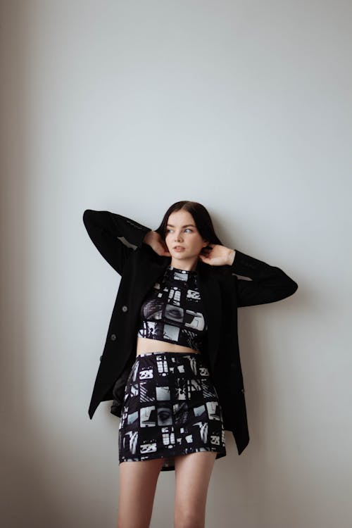 Female Model Wearing a Black Cardigan Posing against a White Wall