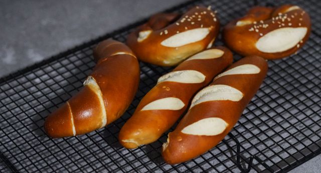 Close-up of freshly baked Bavarian pretzels cooling on a rack, showcasing their golden-brown texture.