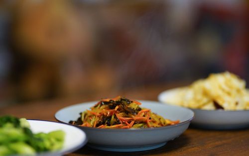 Free A close-up of steaming stir-fried vegetables, broccoli, and crisps on plates, perfect for a flavorful meal. Stock Photo