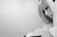 这张单色肖像捕捉了一位裹着舒适兜帽、摆出沉思姿势的女性