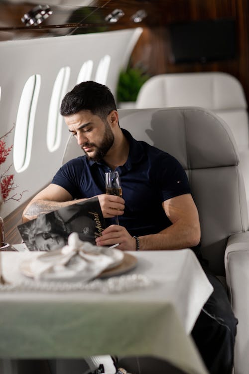Free Man Sitting by Table on Airplane Stock Photo