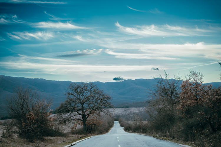 Clouds In Sky Over Long Road In Countryside