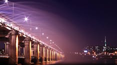 一座照亮桥梁和城市天际线的夜景，展现了充满活力的灯光与建筑