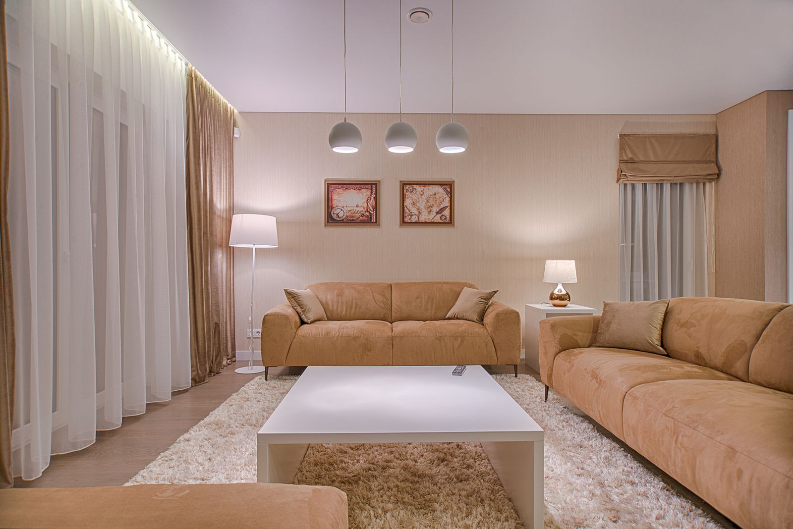 Bright modern living room with tan sofas and pendant lighting