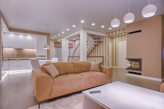 这间豪华客厅采用现代室内设计，配有米色沙发、壁炉和开放式厨房