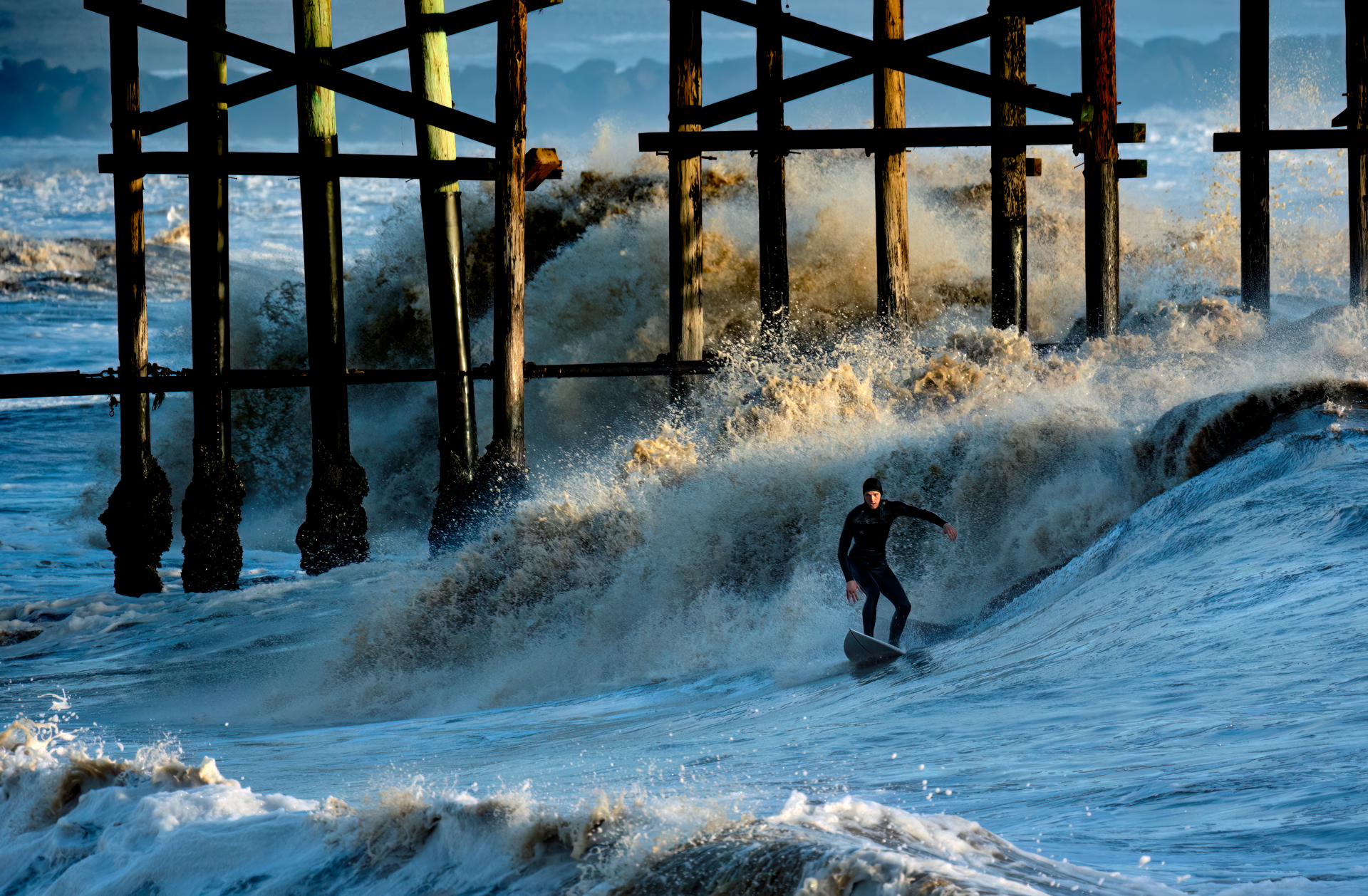 Dynamic shot of a surfer catching waves near Ventura Pier, California.