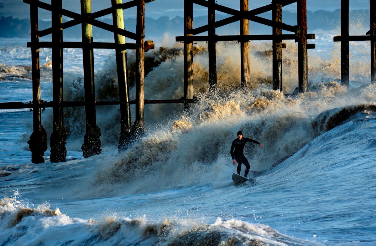 Surfer riding on foamy sea waves · Free Stock Photo