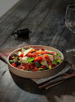 Delicious Caprese salad with fresh tomatoes and mozzarella on a rustic wooden table.