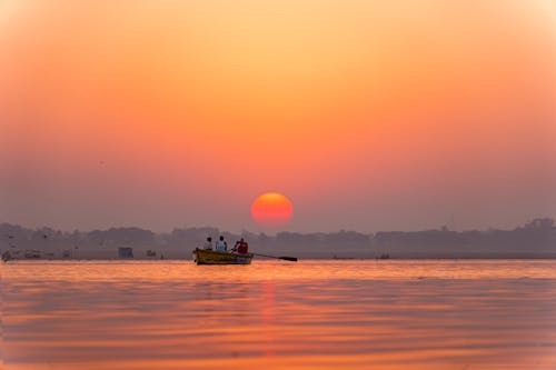 People Boating on Lake at Sunset