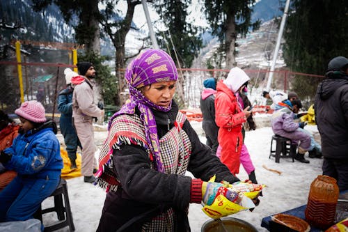 Woman with Purple Headscarf Preparing Street Food at Market