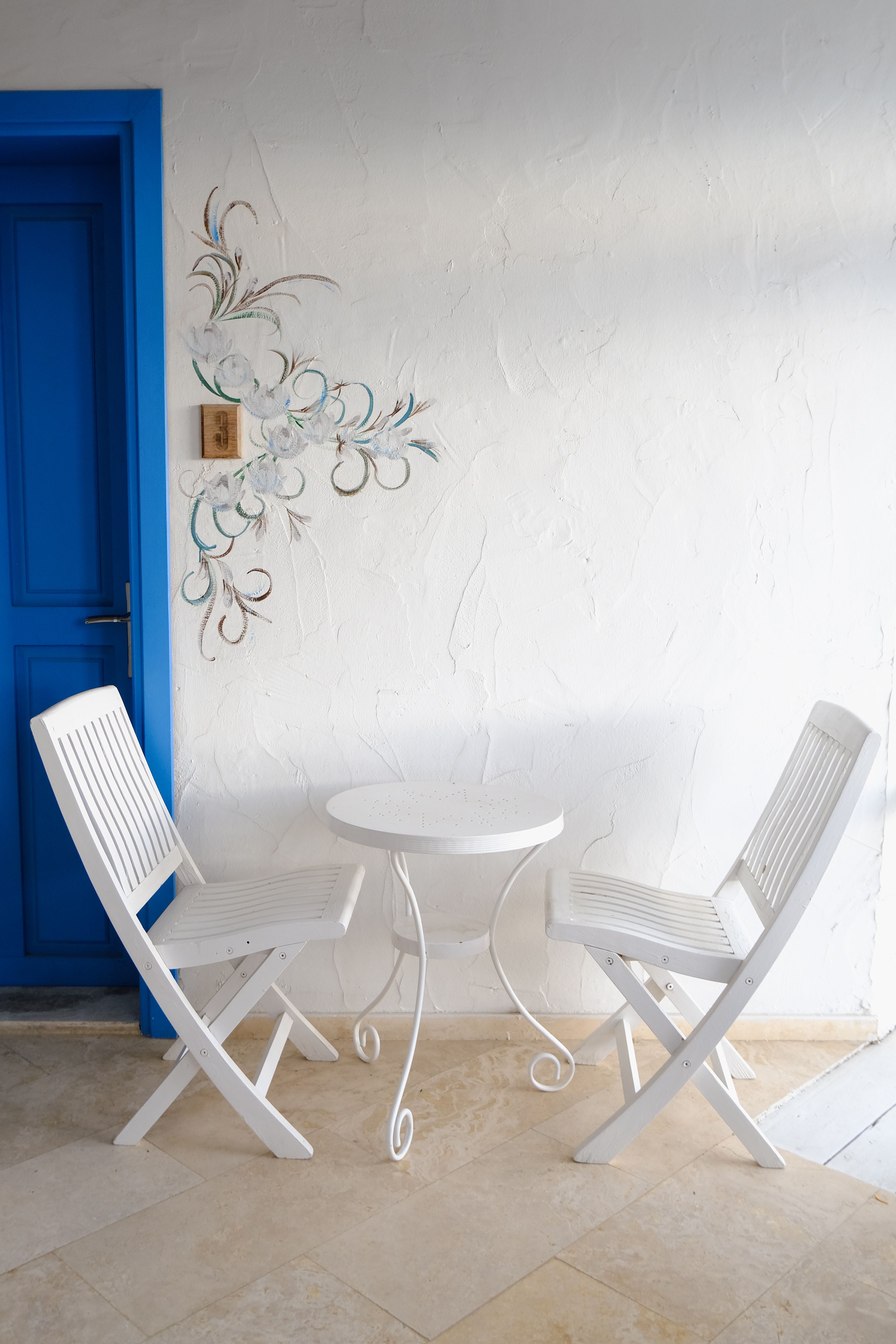 Small fold-down wooden table mounted to a small apartment patio wall, folded up against the railing