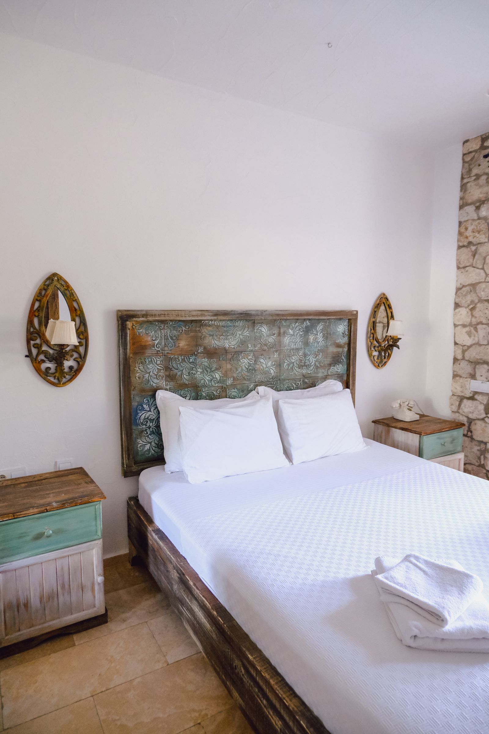A cosy boutique hotel room with a rustic stone accent wall