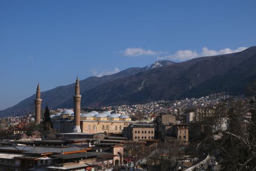 Free A breathtaking aerial view of Bursa, Türkiye highlighting the historic Ulu Mosque against a mountainous backdrop under a clear blue sky. Stock Photo