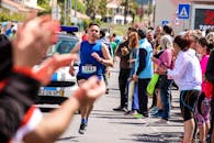 在一场热闹的街头活动中，马拉松运动员在欢呼的人群簇拥下，向着城市中的终点线冲刺