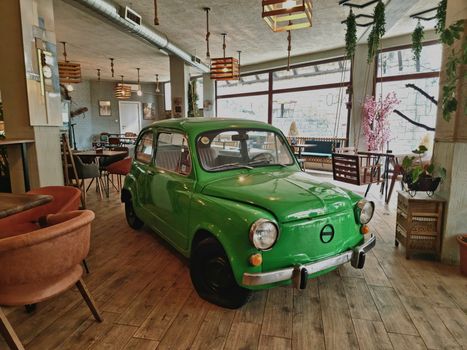Retro Zastava 750 car displayed in a stylish Skopje café, perfect blend of vintage and modern.