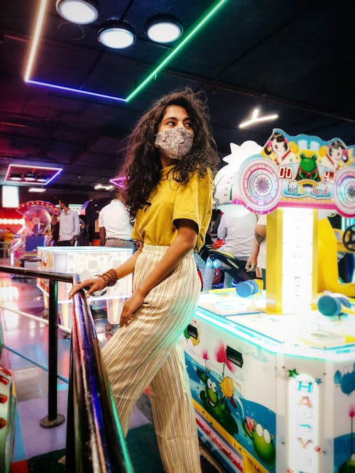 A woman wearing a mask in a game room