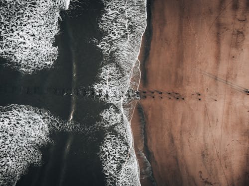 Foto profissional grátis de areia, beira-mar, borrifando