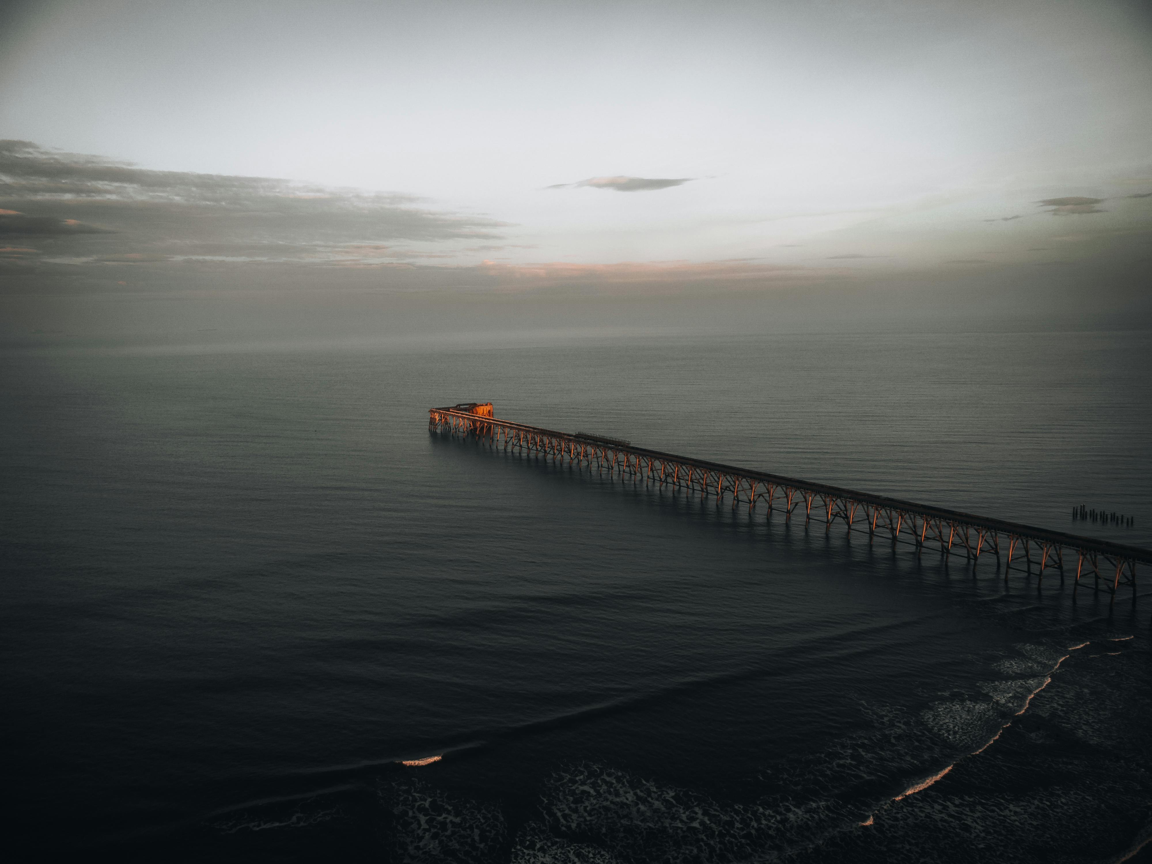 Serene aerial view of Hartlepool Pier at dawn with gentle sea waves and subtle fog.