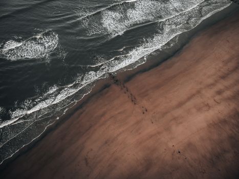 Dramatic aerial shot of Hartlepool beach with waves crashing on the shore during summer.