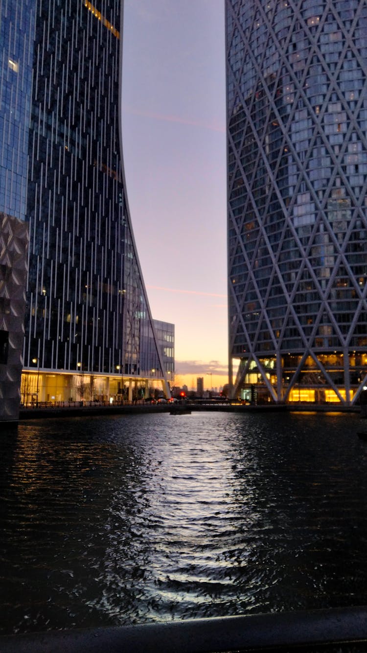 Glass Skyscrapers Near Water In City Downtown At Night