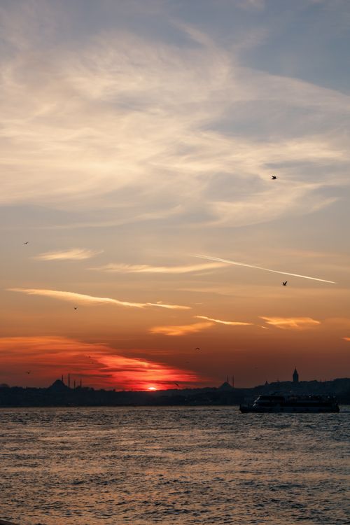 Free Stunning sunset over the Bosphorus with Istanbul landmarks silhouetted against the sky. Stock Photo
