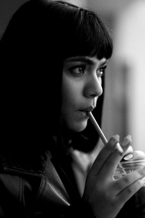 Close-up of Woman Drinking with Straw from Plastic Cup