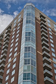 Low angle view of a modern high-rise apartment building in Atlanta against a clear blue sky.