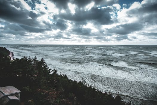 A dramatic view of the Baltic Sea coastline in Latvia with moody skies and waves crashing on the shore.