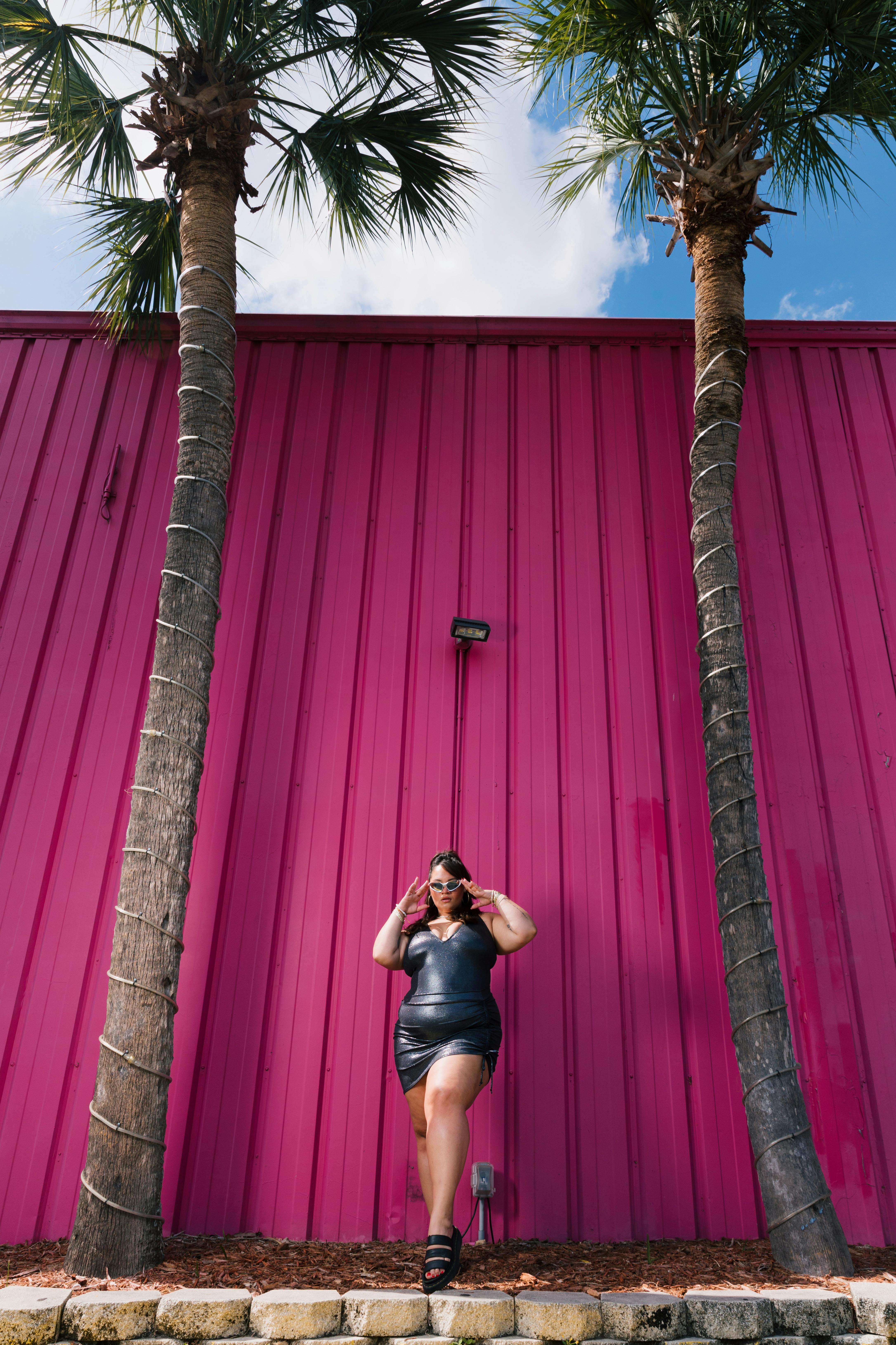 woman standing under palm trees