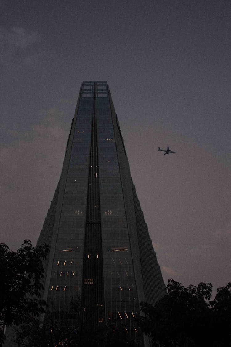 Airplane Flying Near Skyscraper