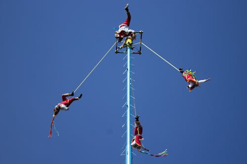 People Hanging on Attraction in Amusement Park