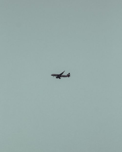 Free A lone airplane soaring through the clear sky, captured from a low angle. Stock Photo
