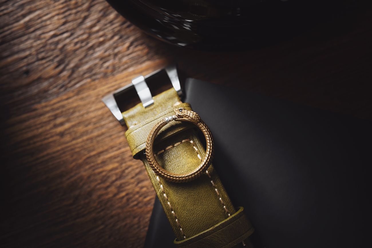 Gold ring resting on a green leather watch strap, showing hand stitching — photo by COPPERTIST WU on Pexels