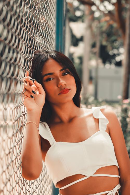 Free Portrait of a stylish woman with brunette hair in a sunny outdoor setting, showcasing fashion and confidence. Stock Photo