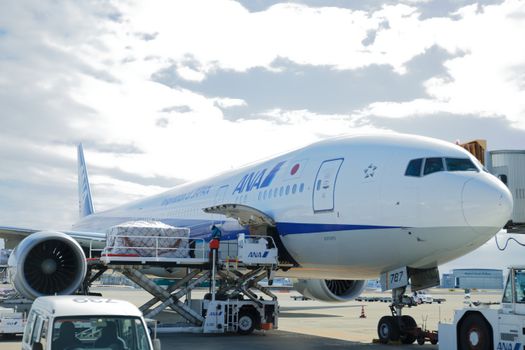 A commercial airplane loaded at an airport terminal, preparing for flight.