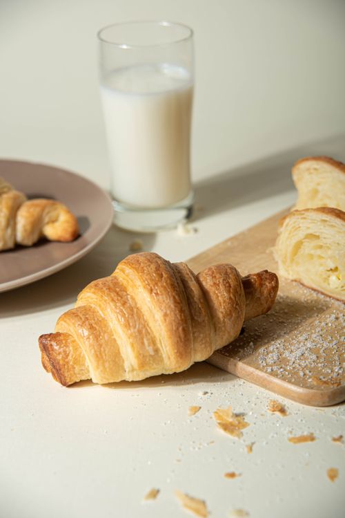 Free A delicious setup with fresh croissants and a glass of milk on a table. Stock Photo
