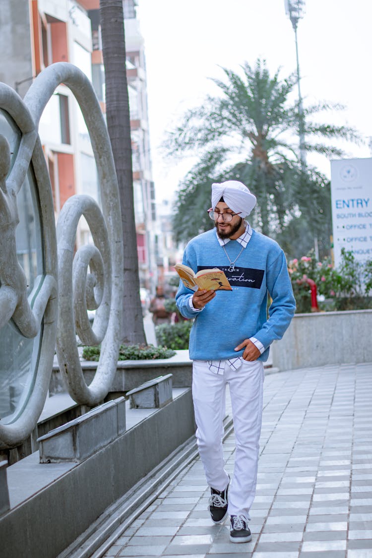 Man Walking And Reading Book