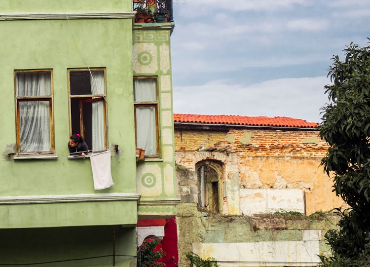 Woman Looking Out Of House Window