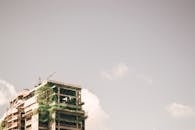 晴朗的天空下，一座现代化高层建筑正在城市环境中拔地而起