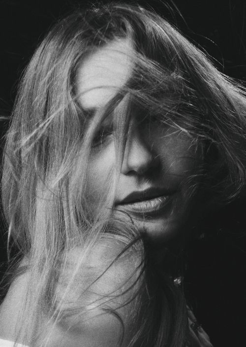 Free Artistic black and white portrait of a woman with hair covering her face, conveying mystery. Stock Photo