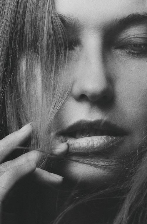 Free A close-up black and white portrait showcasing a woman's face with an intimate expression. Stock Photo