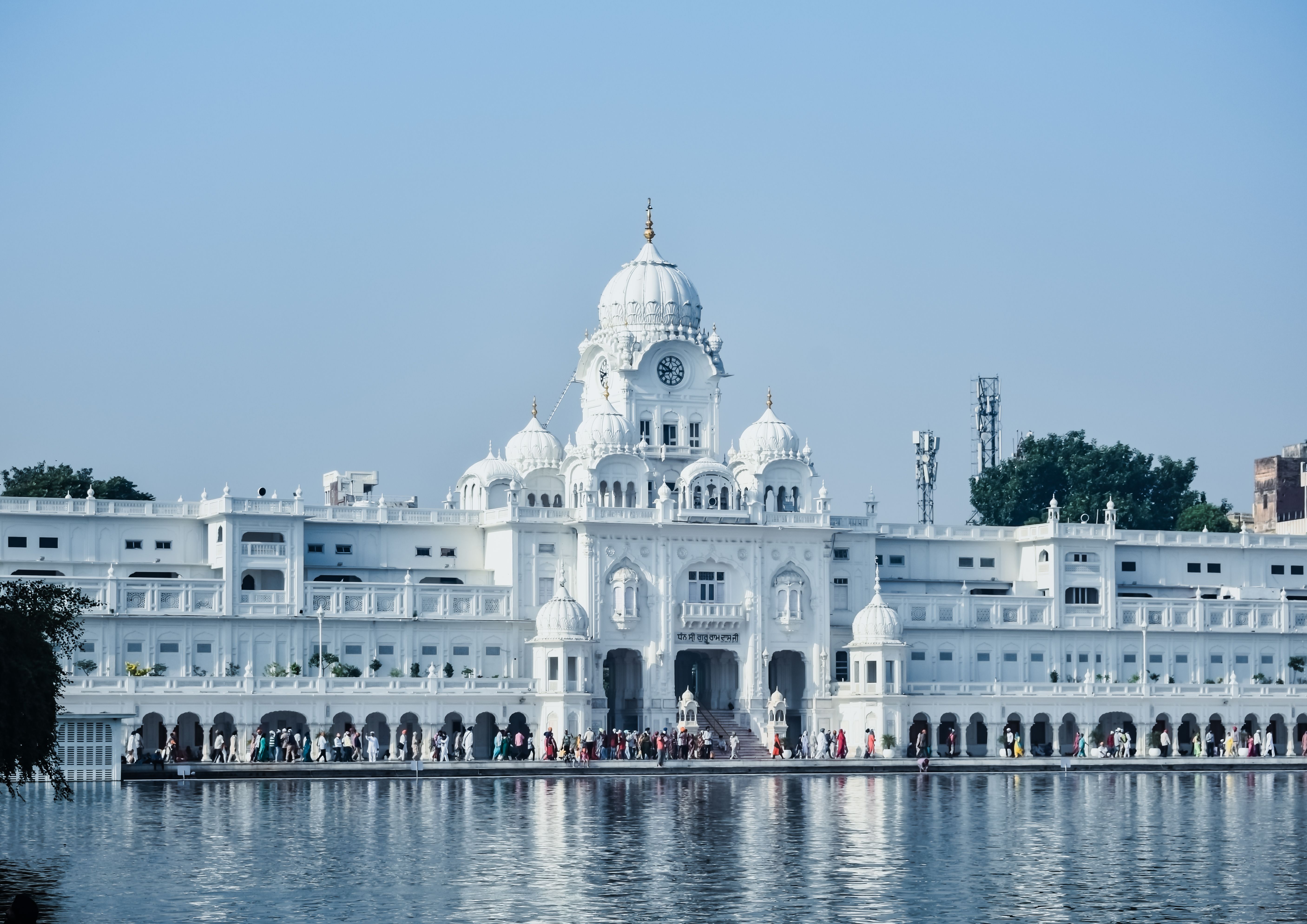 Beautiful view of a historic temple in Amritsar reflected in water, showcasing architectural elegance.