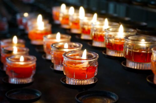 Free A row of lit votive candles in glass holders creates a warm and tranquil atmosphere. Stock Photo
